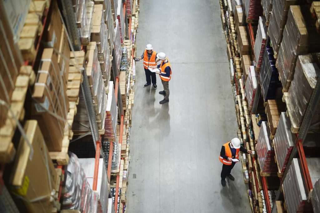 Workers managing inventory in warehouse with Voonami's Fishbowl Hosted Server solution